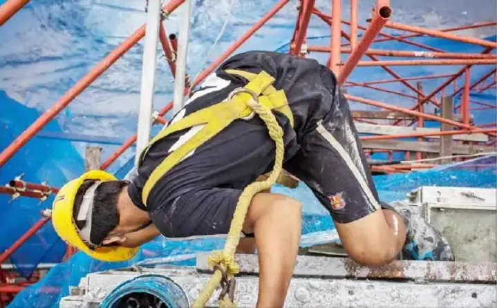 A construction worker strapped in for high-rise work at a building site