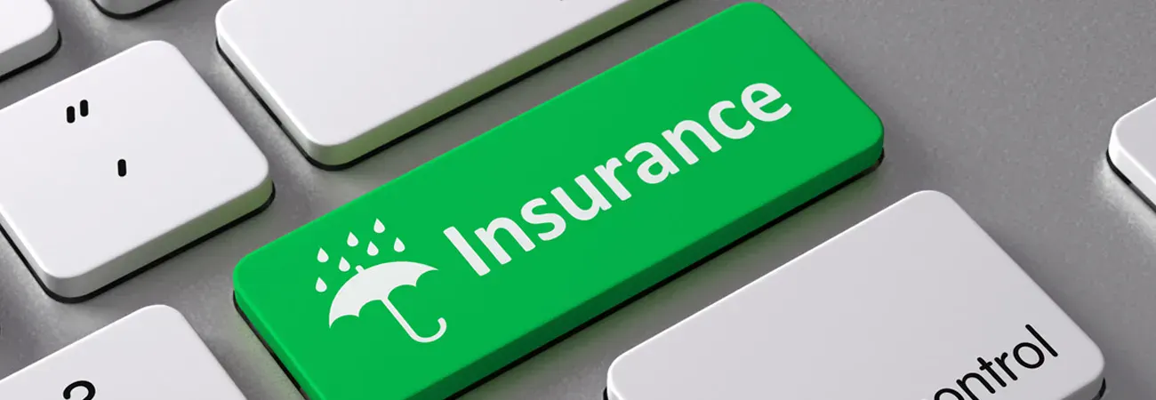 A green insurance key on a computer keyboard