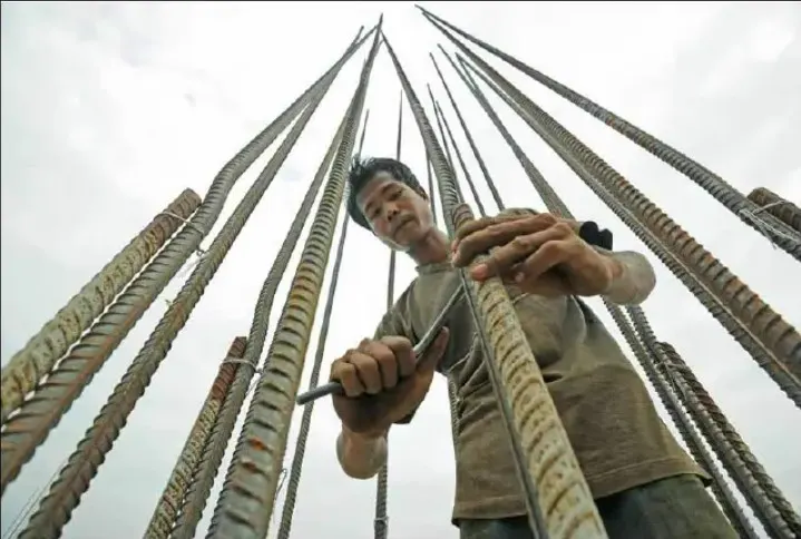 A construction worker inserts rebar on a construction site in Yangon